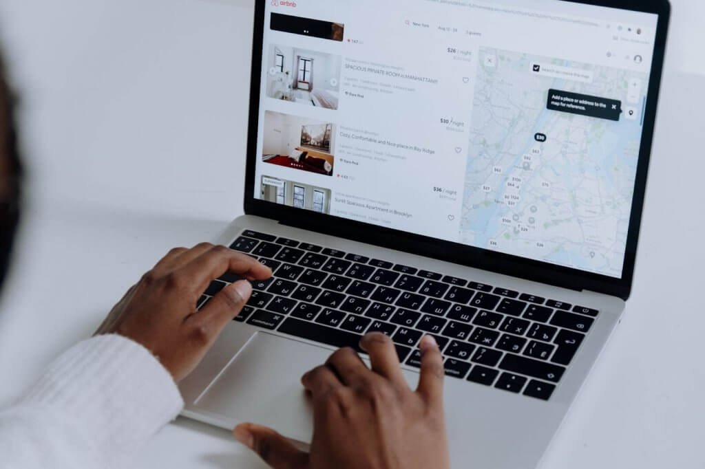 woman looking at airbnb.com on a laptop