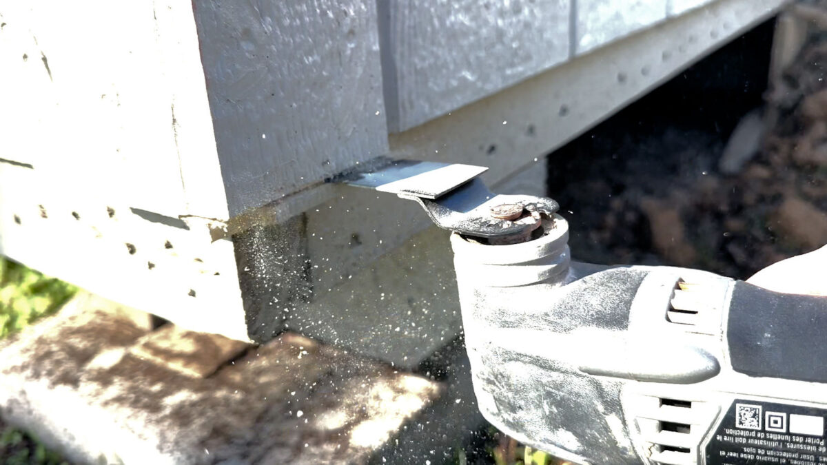 Adding skirting to backyard shed -- if corner trim pieces are too long, cut away excess.