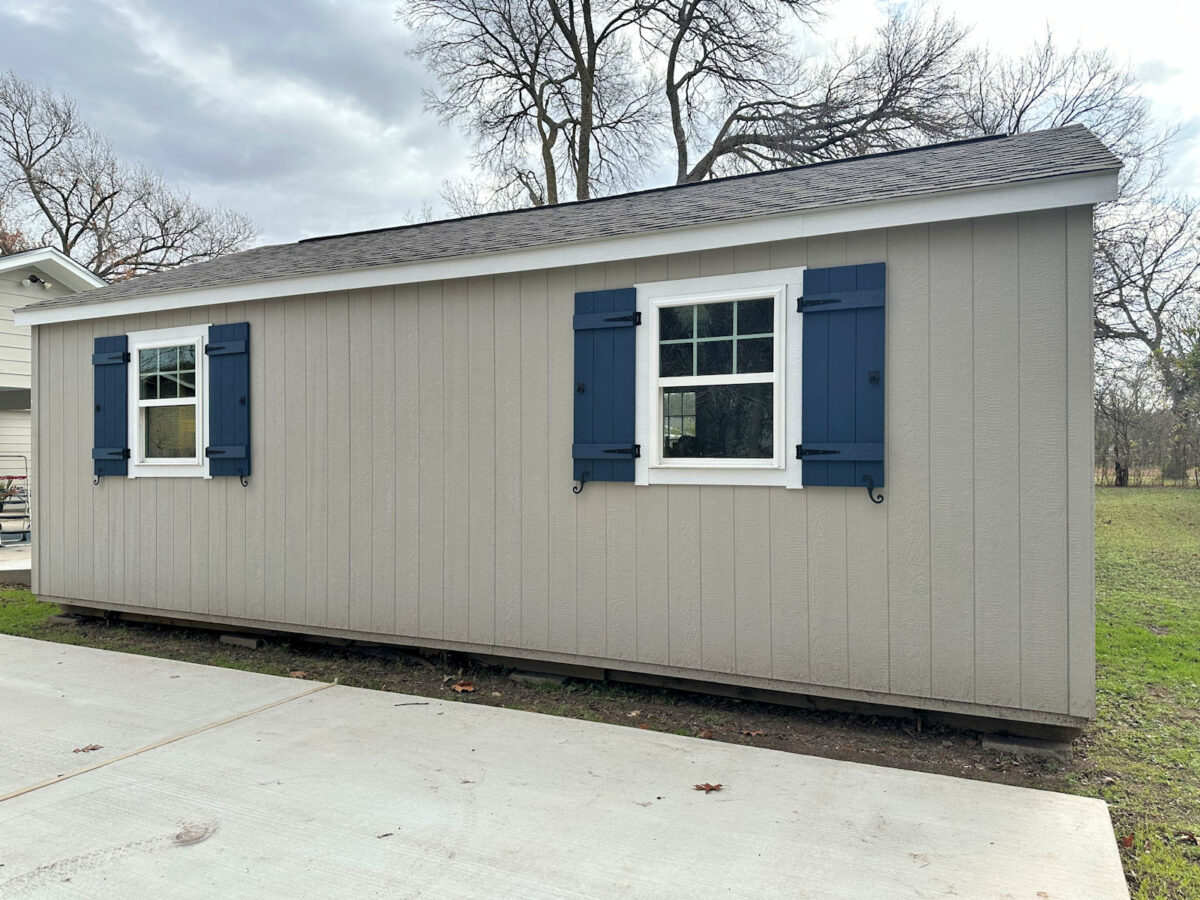 The back side view of my back yard shed workshop -- gray paint, white trim, dark blue shutters